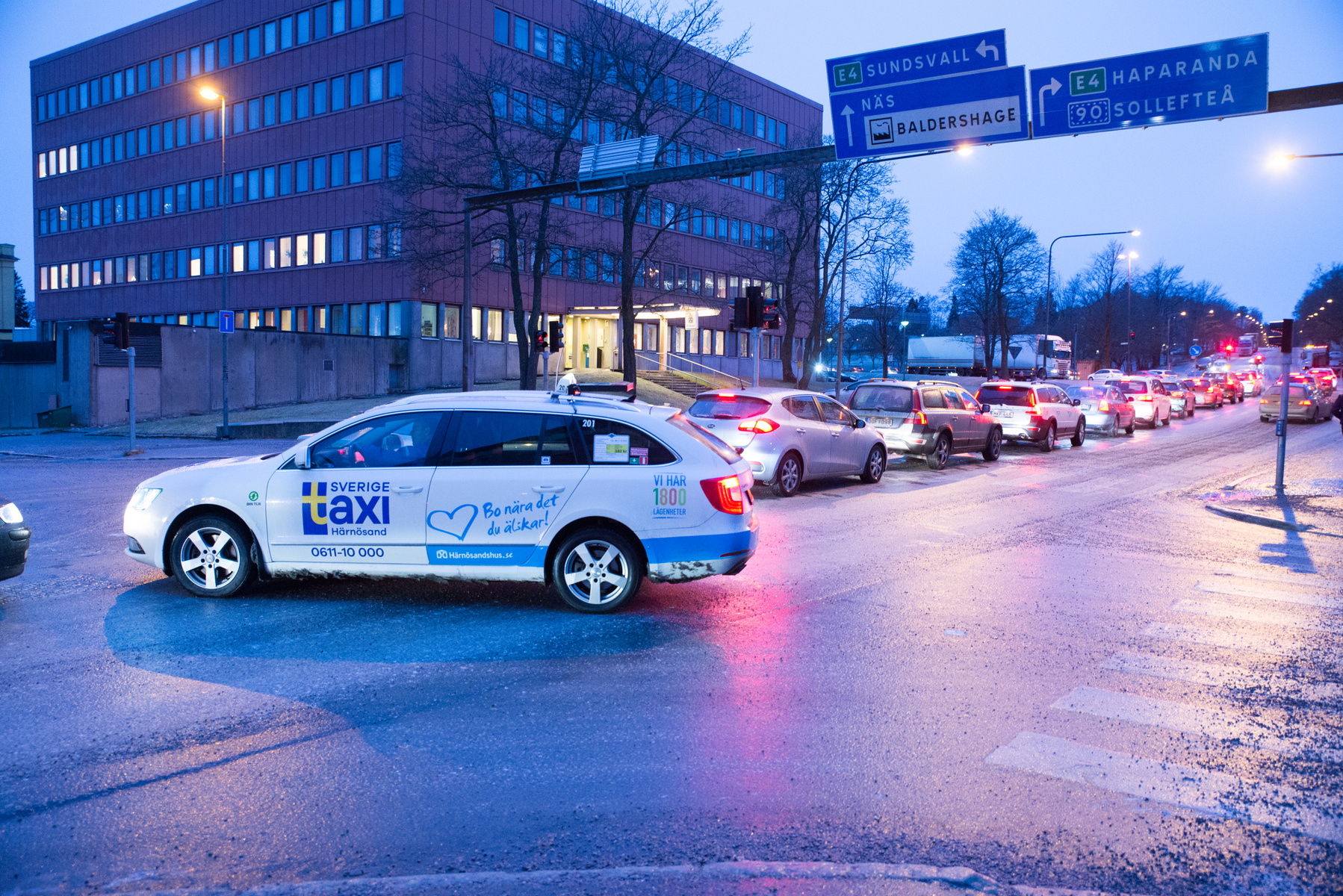 En vit taxibil som kör i en korsning i Sundsvall